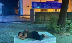 Fahiş kira fiyatlarından yakınan öğrenci, kampüsün kapısına yatak atıp uyudu